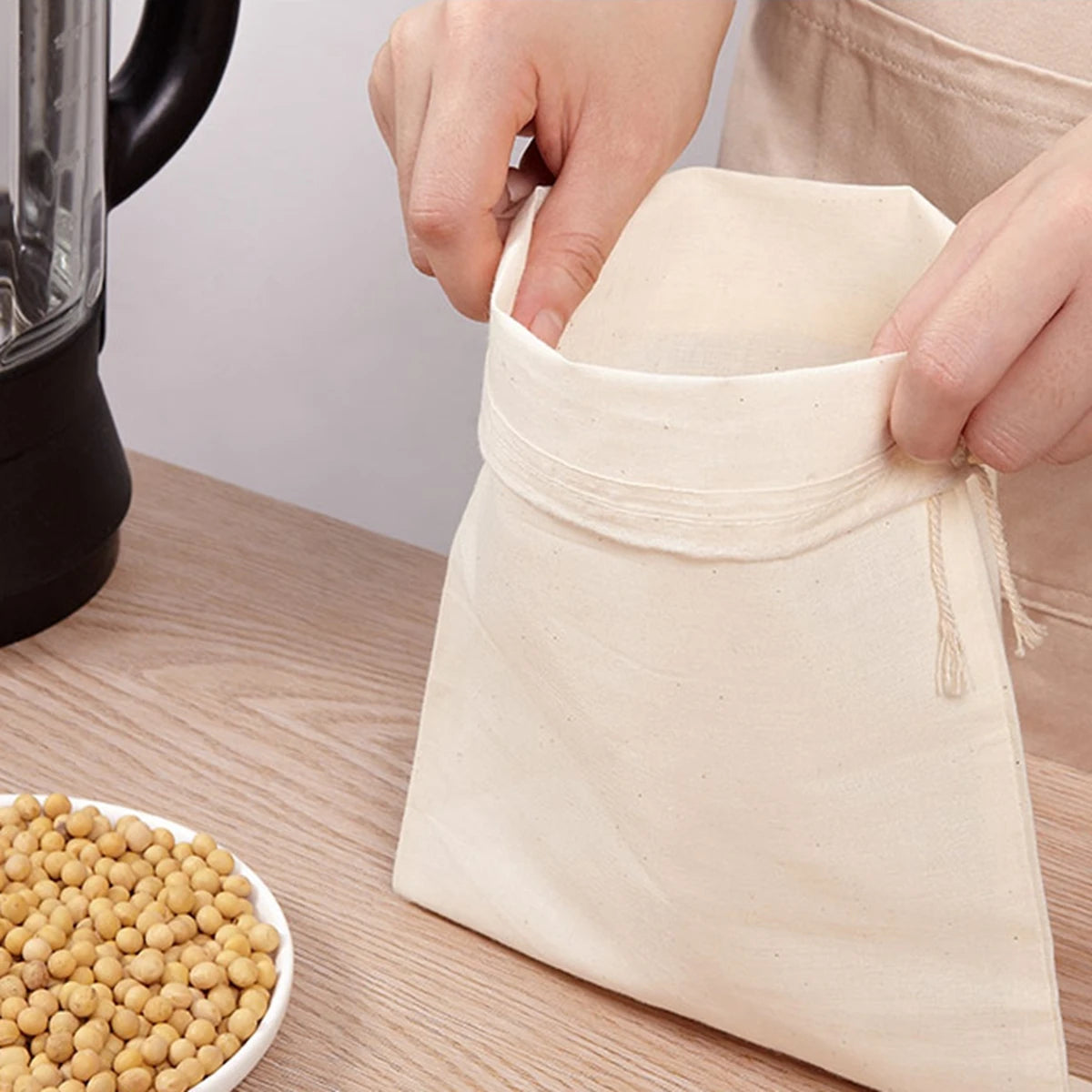 Reusable organic cotton cheesecloth bag with a secure drawstring closure, ideal for making nut milks, broths, and teas. Get yours at KitchenHavenCo