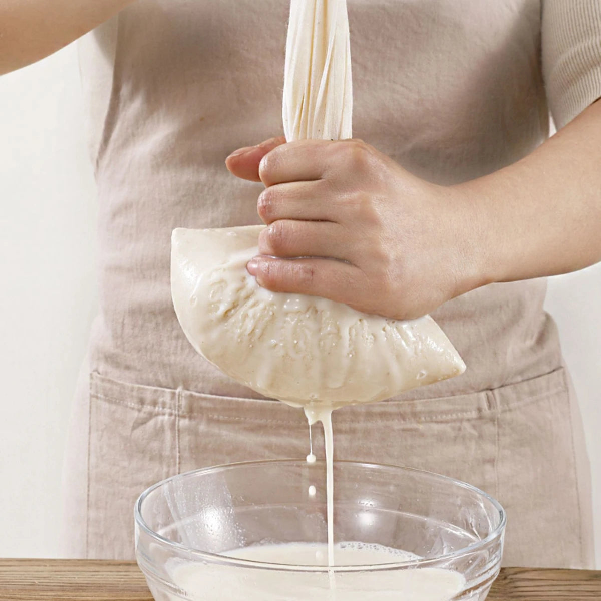 Unbleached organic cotton cheesecloth straining fresh homemade cheese, demonstrating its durability and versatility for kitchen use. Shop now at KitchenHavenCo.